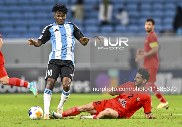 Jacinto Dala of Al Wakrah SC battles for the ball with Mehdi Shiri of Tractor SC during the AFC Champions League football match between Qata...