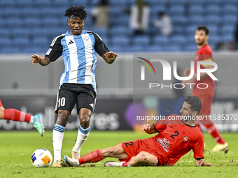 Jacinto Dala of Al Wakrah SC battles for the ball with Mehdi Shiri of Tractor SC during the AFC Champions League football match between Qata...