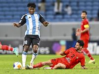 Jacinto Dala of Al Wakrah SC battles for the ball with Mehdi Shiri of Tractor SC during the AFC Champions League football match between Qata...