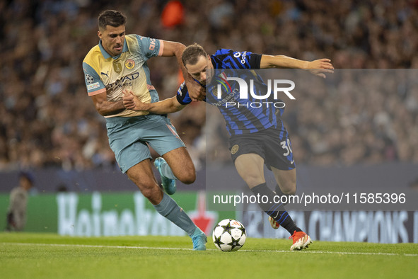 Carlos Augusto #30 of Inter Milan tackles Rodri #16 of Manchester City F.C. during the UEFA Champions League League Stage match between Manc...