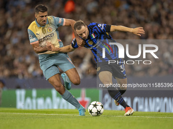 Carlos Augusto #30 of Inter Milan tackles Rodri #16 of Manchester City F.C. during the UEFA Champions League League Stage match between Manc...