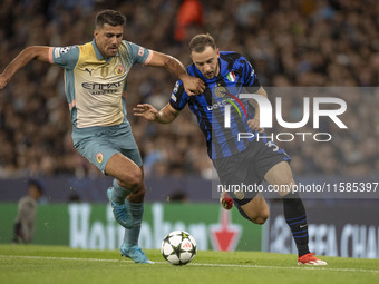 Carlos Augusto #30 of Inter Milan tackles Rodri #16 of Manchester City F.C. during the UEFA Champions League League Stage match between Manc...