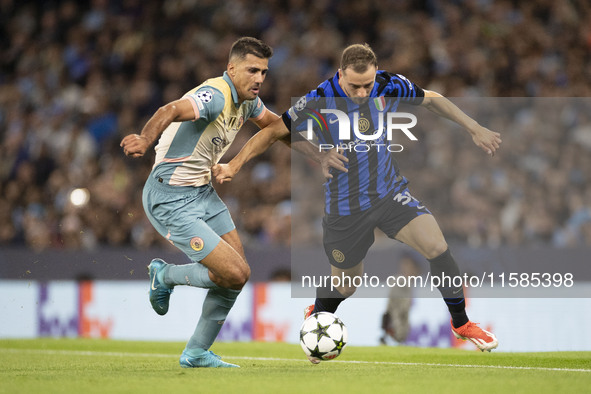 Carlos Augusto #30 of Inter Milan tackles Rodri #16 of Manchester City F.C. during the UEFA Champions League League Stage match between Manc...