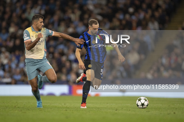 Carlos Augusto #30 of Inter Milan tackles Rodri #16 of Manchester City F.C. during the UEFA Champions League League Stage match between Manc...