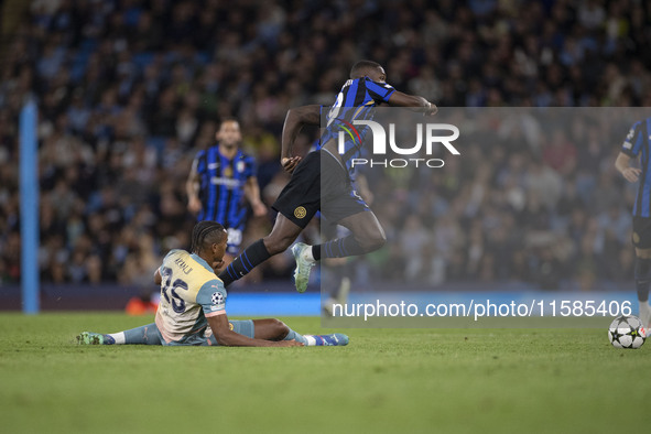 Marcus Thuram #9 of Inter Milan is fouled by Savinho #26 of Manchester City F.C. during the UEFA Champions League League Stage match between...