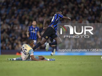 Marcus Thuram #9 of Inter Milan is fouled by Savinho #26 of Manchester City F.C. during the UEFA Champions League League Stage match between...