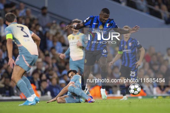 Marcus Thuram #9 of Inter Milan is tackled by Ilkay Gundogan #19 of Manchester City F.C during the UEFA Champions League League Stage match...