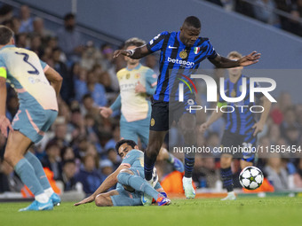 Marcus Thuram #9 of Inter Milan is tackled by Ilkay Gundogan #19 of Manchester City F.C during the UEFA Champions League League Stage match...