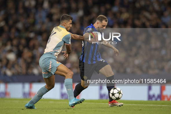 Carlos Augusto #30 of Inter Milan is tackled by Rodri #16 of Manchester City F.C. during the UEFA Champions League League Stage match betwee...