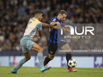 Carlos Augusto #30 of Inter Milan is tackled by Rodri #16 of Manchester City F.C. during the UEFA Champions League League Stage match betwee...