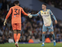 Ederson shakes hands with Phil Foden #47 of Manchester City F.C. during the UEFA Champions League League Stage match between Manchester City...