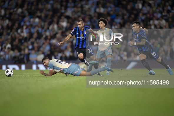 Henrikh Mkhitaryan #22 of Inter Milan is tackled by Rodri #16 of Manchester City F.C. during the UEFA Champions League League Stage match be...