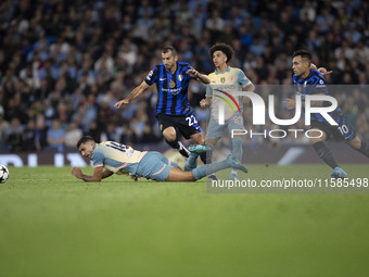 Henrikh Mkhitaryan #22 of Inter Milan is tackled by Rodri #16 of Manchester City F.C. during the UEFA Champions League League Stage match be...