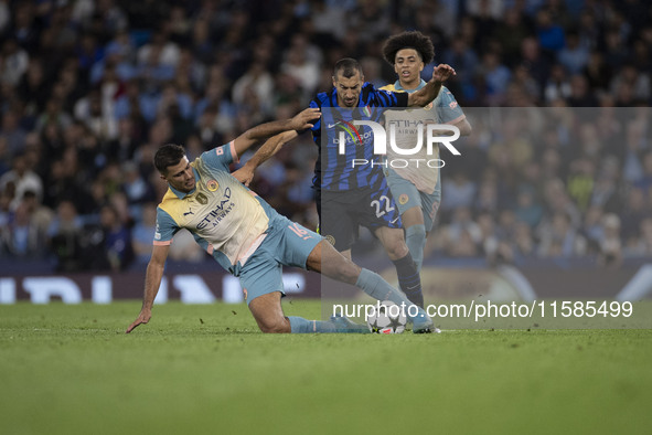 Henrikh Mkhitaryan #22 of Inter Milan is tackled by Rodri #16 of Manchester City F.C. during the UEFA Champions League League Stage match be...