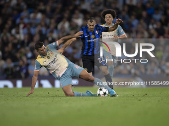 Henrikh Mkhitaryan #22 of Inter Milan is tackled by Rodri #16 of Manchester City F.C. during the UEFA Champions League League Stage match be...