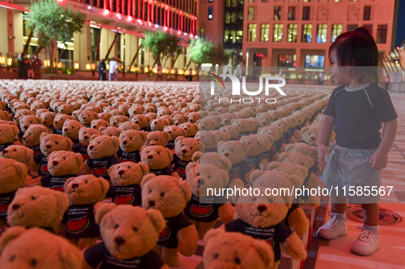 A young child looks at an installation of teddy bears titled ''Echo of Lost Innocence'' at the Barahat Mashaireb open-air gallery to draw at...