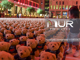 A young child looks at an installation of teddy bears titled ''Echo of Lost Innocence'' at the Barahat Mashaireb open-air gallery to draw at...