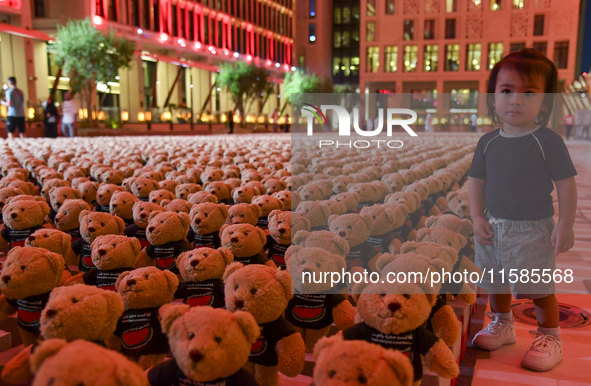 A young child looks at an installation of teddy bears titled ''Echo of Lost Innocence'' at the Barahat Mashaireb open-air gallery to draw at...