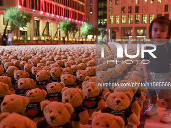 A young child looks at an installation of teddy bears titled ''Echo of Lost Innocence'' at the Barahat Mashaireb open-air gallery to draw at...