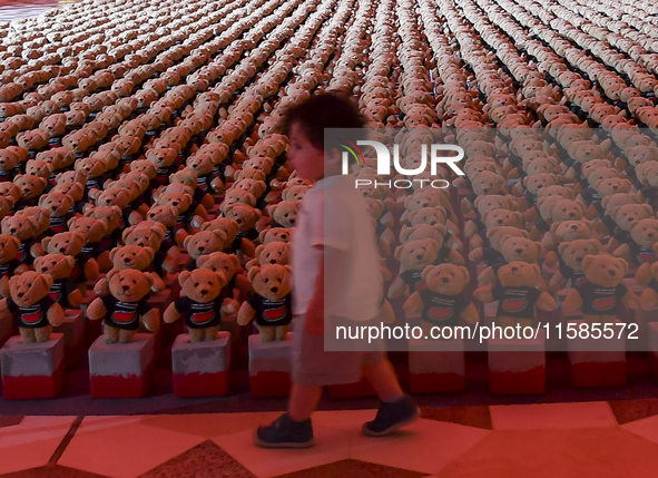 A young child looks at an installation of teddy bears titled ''Echo of Lost Innocence'' at the Barahat Mashaireb open-air gallery to draw at...