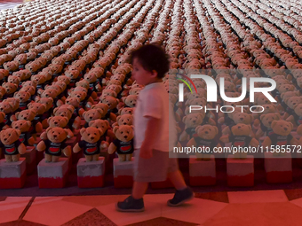 A young child looks at an installation of teddy bears titled ''Echo of Lost Innocence'' at the Barahat Mashaireb open-air gallery to draw at...