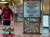 A volunteer carries teddy bears during the installation of ''Echo of Lost Innocence'' at the Barahat Mashaireb open-air gallery to draw atte...