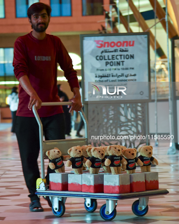 A volunteer carries teddy bears during the installation of ''Echo of Lost Innocence'' at the Barahat Mashaireb open-air gallery to draw atte...