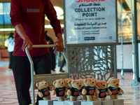 A volunteer carries teddy bears during the installation of ''Echo of Lost Innocence'' at the Barahat Mashaireb open-air gallery to draw atte...