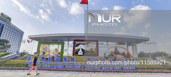 People walk past a sign for the ASEAN Expo in Nanning, China, on September 18, 2024. 