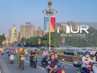 People walk past a sign for the ASEAN Expo in Nanning, China, on September 18, 2024. (