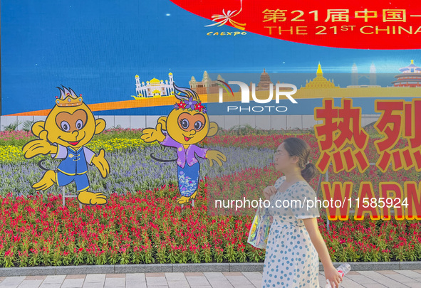 People walk past a sign for the ASEAN Expo in Nanning, China, on September 18, 2024. 