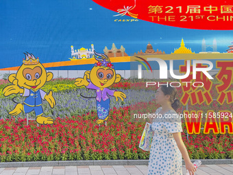 People walk past a sign for the ASEAN Expo in Nanning, China, on September 18, 2024. (