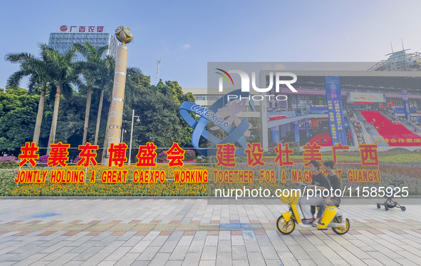 People walk past a sign for the ASEAN Expo in Nanning, China, on September 18, 2024. 