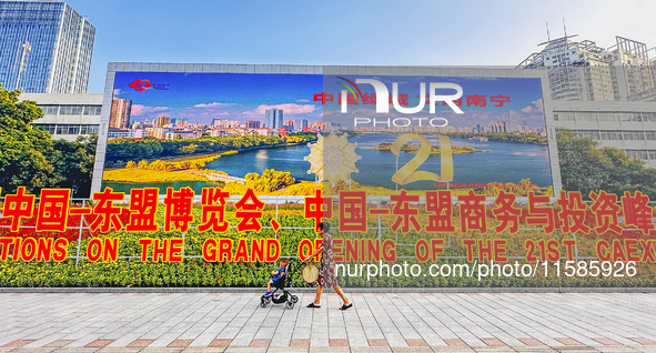 People walk past a sign for the ASEAN Expo in Nanning, China, on September 18, 2024. 