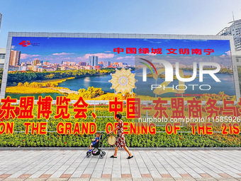 People walk past a sign for the ASEAN Expo in Nanning, China, on September 18, 2024. (