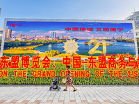 People walk past a sign for the ASEAN Expo in Nanning, China, on September 18, 2024. (