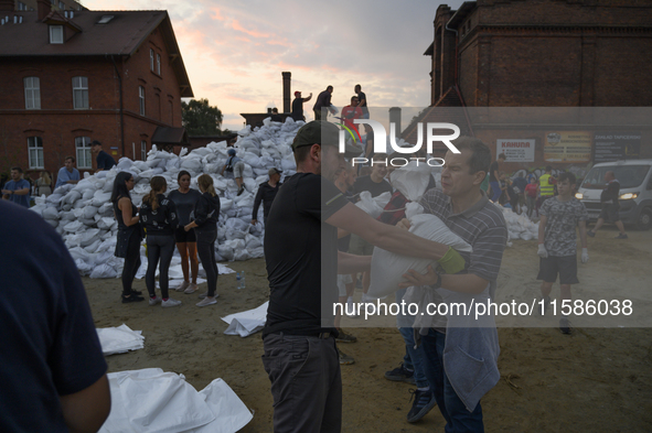 People and territorial defense forces prepare sandbags to tackle the ongoing high water level throughout the region in Olawa, near Wroclaw,...