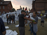 People and territorial defense forces prepare sandbags to tackle the ongoing high water level throughout the region in Olawa, near Wroclaw,...