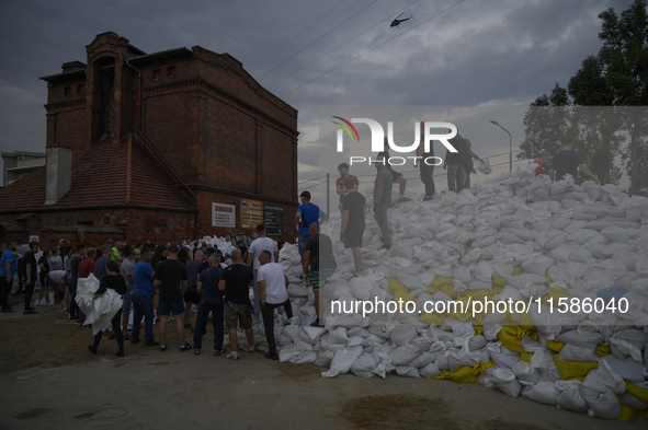 People and territorial defense forces prepare sandbags to tackle the ongoing high water level throughout the region in Olawa, near Wroclaw,...