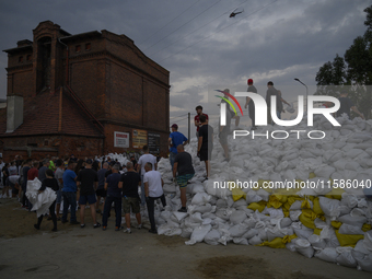 People and territorial defense forces prepare sandbags to tackle the ongoing high water level throughout the region in Olawa, near Wroclaw,...