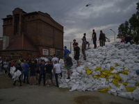 People and territorial defense forces prepare sandbags to tackle the ongoing high water level throughout the region in Olawa, near Wroclaw,...