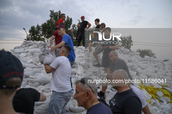 People and territorial defense forces prepare sandbags to tackle the ongoing high water level throughout the region in Olawa, near Wroclaw,...