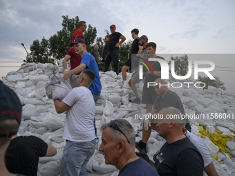 People and territorial defense forces prepare sandbags to tackle the ongoing high water level throughout the region in Olawa, near Wroclaw,...