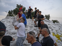 People and territorial defense forces prepare sandbags to tackle the ongoing high water level throughout the region in Olawa, near Wroclaw,...