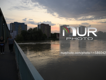 People walk on a bridge above the Oder River in Olawa, near Wroclaw, Poland, on September 18, 2024. Emergency services, including fire depar...