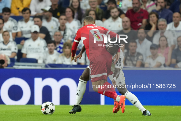 Vinicius Junior left winger of Real Madrid and Brazil and Enzo Millot attacking midfield of Stuttgart and France compete for the ball during...