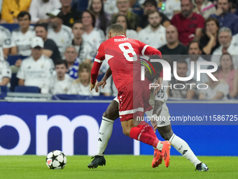 Vinicius Junior left winger of Real Madrid and Brazil and Enzo Millot attacking midfield of Stuttgart and France compete for the ball during...