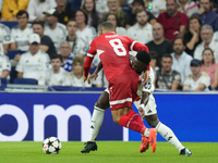 Vinicius Junior left winger of Real Madrid and Brazil and Enzo Millot attacking midfield of Stuttgart and France compete for the ball during...