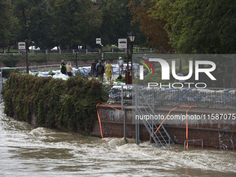 People walk next to sandbags during high waters in the Oder River in Wroclaw, Poland, on September 19, 2024. (