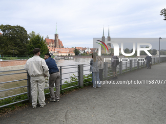 People take pictures of the high water level in the Oder River in Wroclaw, Poland, on September 19, 2024. (